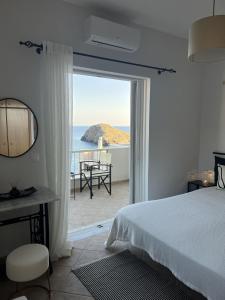 a bedroom with a bed and a view of the ocean at Ninemia Apartment in Kaloi Limenes