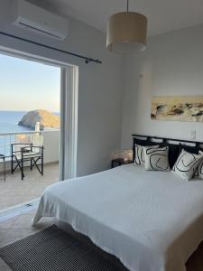 a bedroom with a bed with a view of the ocean at Ninemia Apartment in Kaloi Limenes