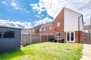 una casa in mattoni con recinzione e cortile di Contractors Retreat 3 bed house, sleeps up to 7, free parking a Milton Keynes