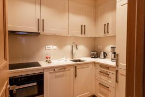 een keuken met witte kasten en een wastafel bij Porto Montesun Apartments in Tivat