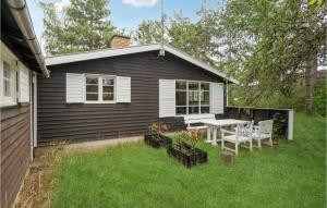 a small house with a table and chairs in the yard at Lovely Home In Solrd Strand With Wifi in Karlstrup Strand