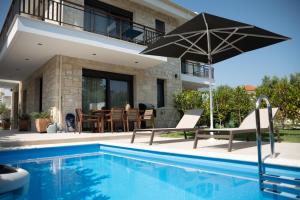 a villa with a swimming pool and a house at Pietra Mare Villas in Polychrono
