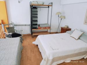 a bedroom with two beds and a chair and a mirror at Apartamento Premium Relax C in Bárcena de Cicero