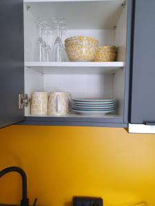a cupboard with plates and dishes in it at Kleine Milchbar in Norderney
