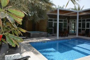 a swimming pool in front of a house at Dar 66 Pool Chalets with Jacuzzi in Ras al Khaimah