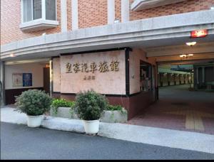 um edifício com dois vasos de plantas em frente em Huang Jia Hotel em Yongkang