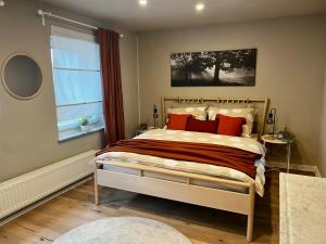 Schlafzimmer mit einem Bett mit roten Kissen und einem Fenster in der Unterkunft Ferienhaus „große Familie“ in Zülpich