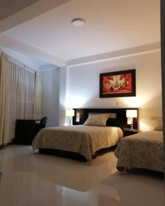 En eller flere senge i et værelse på D'eluxe Hotel Talara ubicado a 5 minutos del aeropuerto y a 8 minutos del Centro Civico