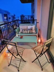 ein Sofa und zwei Stühle auf einem Balkon mit Beleuchtung in der Unterkunft Mediterranean Abode - Spacious Apartment in Swieqi in Is-Swieqi