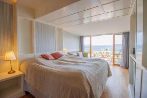 1 dormitorio con 1 cama y vistas al océano en Stammershalle Badehotel en Bådsted