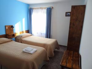 a hotel room with two beds and a window at Casa de Grillos in El Calafate