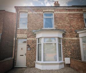 a brick house with a white door and windows at Hill View in Great Ayton in Great Ayton