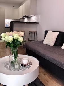 a living room with a table with a vase of flowers at Apartament Rzeszów Centrum II in Rzeszów