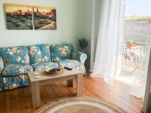 Corfu Fortress Apartment في Ágios Rókkos: غرفة معيشة مع أريكة زرقاء وطاولة
