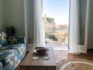 Ágios RókkosにあるCorfu Fortress Apartmentのリビングルーム(ソファ、テーブル付)、窓が備わります。