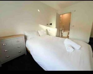 een slaapkamer met een wit bed, een dressoir en een spiegel bij Modern 2bed 2bath in Leith in Edinburgh
