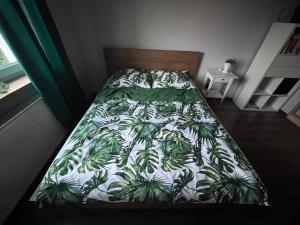 - un lit avec une couette verte et blanche dans une chambre dans l'établissement Apartament Zielony Raj, à Wałbrzych