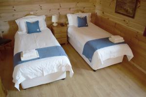 2 camas en una habitación con paredes de madera en Arran Lodge, Isle of Harris en Manish