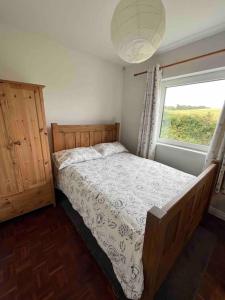 Schlafzimmer mit einem Bett und einem Fenster in der Unterkunft Harbour View Cottage, Rochespoint, Cork Harbour in Midleton