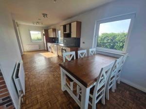 a kitchen with a wooden table and a large window at Harbour View Cottage, Rochespoint, Cork Harbour in Midleton