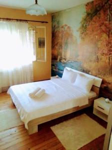 una camera da letto con un letto grande con un dipinto sul muro di Timočko gnezdo a Zaječar