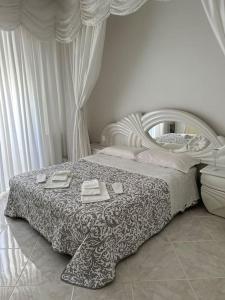 a white bedroom with a bed and a mirror at Casa Eleonora: a 5 min dal mare + free parking in Ventimiglia