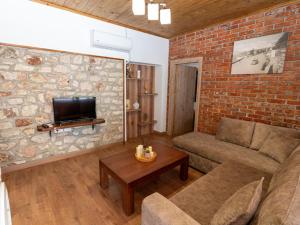 a living room with a couch and a brick wall at Roel Apartments in Sarandë