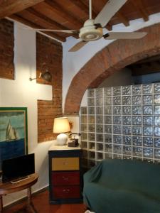 a room with a ceiling fan and a table with a laptop at Real Taste of Tuscany in Florence