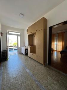 a room with a kitchen with a large wooden cabinet at Apartments Andrović in Ulcinj +11 photos