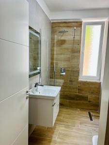 uma casa de banho com um lavatório e uma janela em CoastAL em Shëngjin