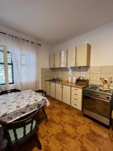 a kitchen with a table and a stove top oven at Apartments Andrović in Ulcinj