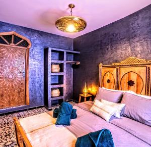 a bedroom with a large bed and a blue wall at Old world charm, modern comfort in Chefchaouen