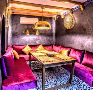 a room with a pink couch and a table at Old world charm, modern comfort in Chefchaouen