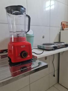 a red blender sitting on a counter in a kitchen at Pousada Jereissati in Maracanaú