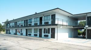 un edificio de apartamentos con balcones y aparcamiento en Anderson Inn, Anderson, Indiana, en Anderson