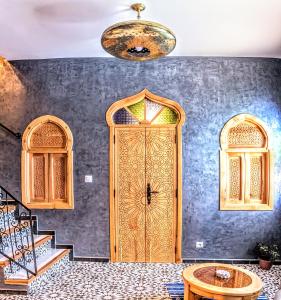 een houten deur in een kamer met een trap bij Old world charm, modern comfort in Chefchaouene
