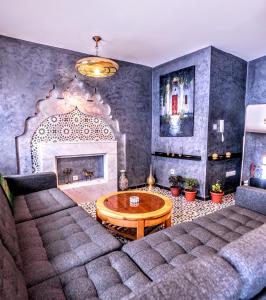 een woonkamer met een bank en een open haard bij Old world charm, modern comfort in Chefchaouene