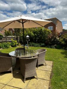 a table with an umbrella in a yard at Flavian House in Chichester