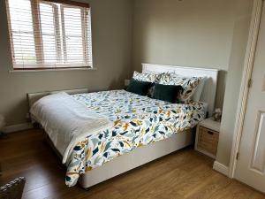 a bedroom with a bed with a white bedspread and pillows at Flavian House in Chichester