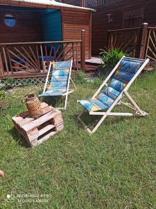 twee stoelen in het gras in een tuin bij Horizons Caraïbes in Sainte-Luce