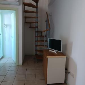 Habitación con ordenador en un escritorio con escalera en Lugano Residence, en Rímini
