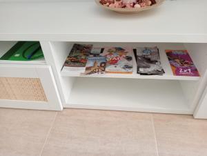 einen weißen Tisch mit Zeitschriften und Büchern darauf in der Unterkunft Villa Lilibella in San Juan de los Terreros