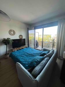 - une chambre avec un lit, un canapé et une fenêtre dans l'établissement Appartement Rouen terrasse + parking, à Rouen