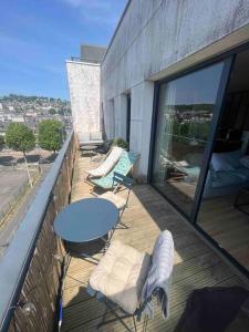 d'une terrasse avec une table et des chaises sur un balcon. dans l'établissement Appartement Rouen terrasse + parking, à Rouen