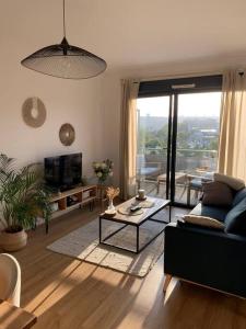 - un salon avec un canapé et une table dans l'établissement Appartement Rouen terrasse + parking, à Rouen