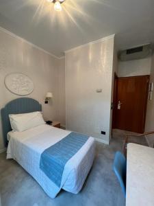ein Hotelzimmer mit einem Bett mit einer blauen Decke in der Unterkunft Hotel Excelsior Bay in Malcesine