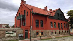 ein orangefarbenes Gebäude mit rotem Dach in der Unterkunft Alte Försterei in Thale