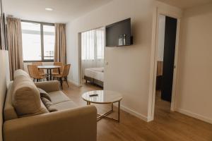 赫雷斯－德拉弗龍特拉的住宿－esZentrico Suites Jerez，客厅配有沙发和桌子
