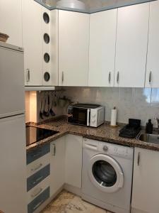 a kitchen with a washing machine and a microwave at Milenium Palace - Garaje incluido - Piscina-FIBES in Seville +11 photos