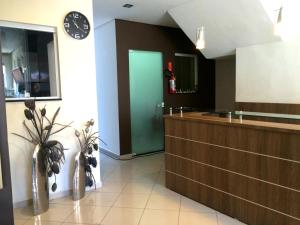 a bathroom with a counter and a green door at Scarpelli Palace Hotel in Sorocaba